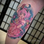 Фото тату Мадоки Канадзе из аниме Madoka Magica на руке. Яркий и красочный рисунок с использованием пастельных тонов.