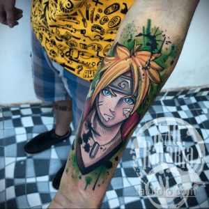 Фото татуировки на руке с изображением Наруто Узумаки из аниме Naruto. Яркие цвета, динамичная поза и детализированная прорисовка.