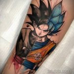 Фото тату: цветная татуировка в стиле аниме с изображением персонажа Гоку из Dragon Ball в форме Супер Сайяна. Динамичная поза, яркие цвета.