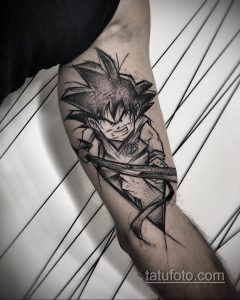 Фото тату на руке с изображением Гоку из Dragon Ball Z в момент концентрации, выполненное в черно-белом стиле.
