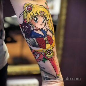 Фото тату на руке с изображением Sailor Moon, аниме персонажа, с ее кошкой Луной и розой. Яркие цвета и детализированная проработка.