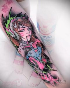 Фото тату: героиня D.Va из игры Overwatch с розовыми акцентами и неоновым свечением на руке.