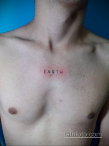 Фото тату на груди: минималистичная надпись 'EARTH' красным цветом. Простой и лаконичный рисунок татуировки.