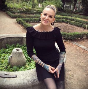Фото татуировок на руках и ноге женщины. На руках изображены геометрические узоры, а на ноге – небольшая татуировка.