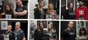 Фото тату: Группа людей, мастера тату и их клиенты, держат сертификаты в тату-студии. Разнообразие стилей татуировок.