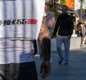 Фото татуировки на руке: детальное изображение ангела с весами, религиозных символов и надписи "MMA" в реалистичном стиле. Черно-белая татуировка.