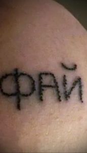 Фото тату с надписью 'Фрай', выполненной черными чернилами на руке. Простой, минималистичный рисунок татуировки, подходящий для поклонников музыки.