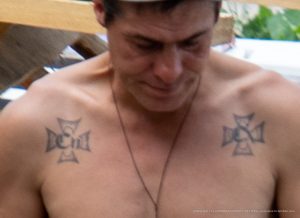 Фото тату: Два черных креста на плечах мужчины. Рисунки выполнены в минималистичном стиле с четкими линиями.