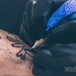 Фото процесса татуировки: рука мастера с тату-машинкой наносит рисунок на кожу. Идеально для тех, кто интересуется процессом создания татуировок.