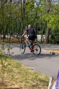 Фото тату: велосипедист с татуировкой на руке, едущий по дороге. Изображение передает ощущение движения, свободы и активного образа жизни.