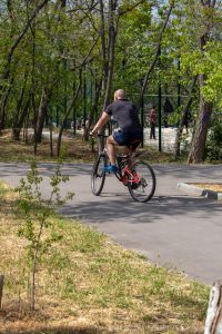 Фото тату: минималистичная татуировка на руке велосипедиста во время движения. Изображение демонстрирует динамику и свободу.