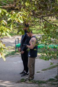 Фото татуировки дракона на плече мужчины. Татуировка выполнена в черно-серых тонах, с детальной проработкой чешуи и крыльев дракона.