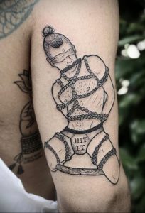 Фото татуировки с изображением человека в BDSM-стиле. Черно-белая графика, детализированный рисунок, провокационный дизайн. Идеи для тату.