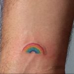 Фото тату на запястье: маленькая, минималистичная радуга. Символизирует надежду, позитив и поддержку ЛГБТК+ сообщества.