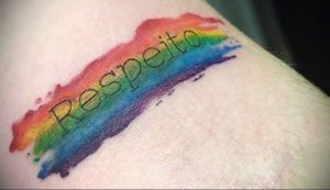 Фото тату: радужная надпись "Respeito" (Уважение) на руке. Яркий и символичный эскиз, выражающий поддержку равенства.