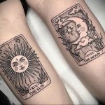 Фото тату на предплечьях пары, изображающие карты Таро Солнце и Луна в стиле blackwork. Детализированные рисунки с точками и линиями.