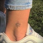 Фото тату на лодыжке: Маленькое Солнце, выполненное в виде тонких линий, минималистичный дизайн.