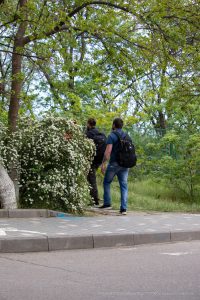 Фото тату на спине мужчины: детализированный рисунок, частично скрытый одеждой. Сложная композиция, темные тона.