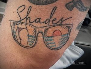 Татуировка на руке с изображением солнцезащитных очков и надписью 'Shades'. Стильный и лаконичный дизайн.