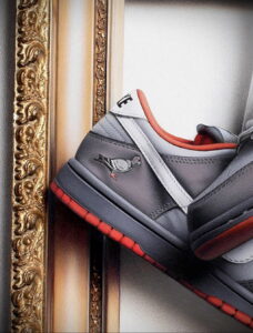 Фотография кроссовок Nike Dunk Pigeon, представленных в художественном исполнении на фоне золотой рамы. Идеально для вдохновения и создания эскизов тату.