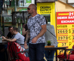 Фото: мужчина в рубашке с принтом, имитирующим татуировки на теле. Принт включает в себя различные рисунки, такие как цветы, животные и геометрические узоры.