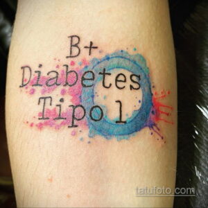 Акварельная татуировка с надписью 'B+ Diabetes Tipo 1' и голубым кругом. Яркий и красочный рисунок татуировки на предплечье.