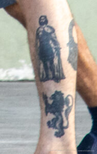 Фото тату на руке: изображение воина в капюшоне и льва. Черно-серые тона, детализированная проработка, стиль реализм. Идеи для тату.