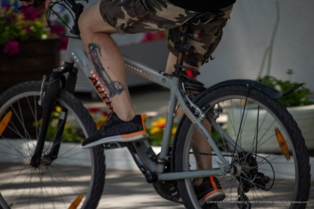 Черно-красная тату с шутом на ноге велосипедиста – Уличная татуировка (Street tattoo) № 04 – 12.06.2020 для tatufoto.com 3
