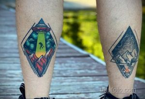 Фото парных татуировок на ногах: одна татуировка изображает НЛО над горами, другая - грозовой шторм над горами. Рисунки выполнены в ярком, графическом стиле.