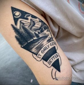 Фото тату с изображением горного пейзажа, леса и озера с надписью "It only gets better". Черно-белая графика, детализированный рисунок, мотивирующий смысл.