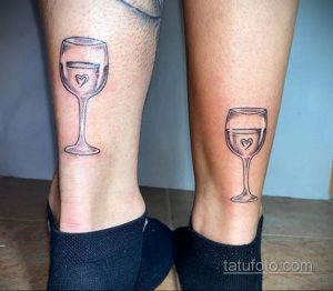 Фото парных татуировок на лодыжках: два одинаковых рисунка бокала красного вина с маленьким сердечком внутри.