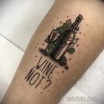 Фото тату: рисунок бутылки вина и бокала с надписью "WINE NOT?". Стильный и юмористический дизайн на руке.
