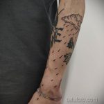 Черно-белое фото тату на руке с изображением падающих капель дождя и букв. Простой и элегантный рисунок татуировки.