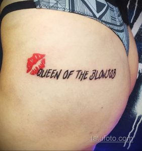 Фото татуировки с красными губами и надписью "QUEEN OF THE BLOWJOB" на боку. Смелый и откровенный рисунок.