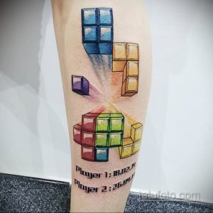 Фото тату на икре с изображением блоков из игры Тетрис. Яркие цвета, геометрические формы и динамичная композиция.