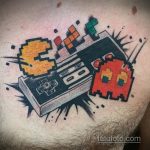 Фото тату на груди с изображением Pac-Man, геймпада и кубиков Рубика. Яркие цвета, динамичная композиция и пиксельный стиль.