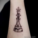 Фото тату на предплечье с изображением шахматного короля в стиле dotwork. Черно-белый рисунок, выполненный с использованием множества точек.