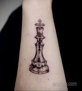 Фото тату на предплечье с изображением шахматного короля в стиле dotwork. Черно-белый рисунок, выполненный с использованием множества точек.