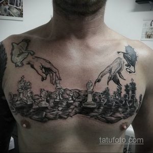Фото тату на груди с изображением масштабной шахматной партии. Черно-белый рисунок с детальной проработкой фигур и абстрактным фоном.