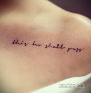 Фото тату с надписью 'this too shall pass' на груди. Минималистичный шрифт, черные чернила на светлой коже.