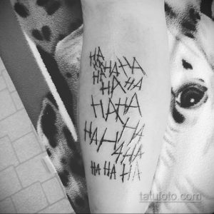 Фото тату с надписью "HAHAHA" в хаотичном стиле на руке. Черно-белая минималистичная татуировка.