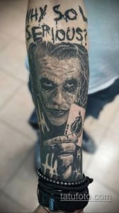 Фото тату Джокера с надписью "Why So Serious?". Черно-белый рисунок с высокой детализацией и реалистичным портретом.