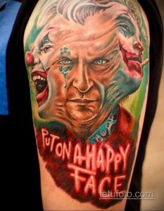 Фото тату Джокера с ярким гримом и надписью "Put on a Happy Face". Использование ярких цветов и реалистичной прорисовки.