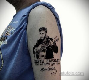 Фото тату Элвиса Пресли, играющего на гитаре, с подписью 'Elvis Presley King of Rock and Roll', выполненного в черно-белом стиле на руке.