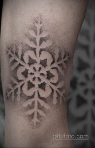 Фото тату большой снежинки, выполненной в технике dotwork. Черно-белый рисунок татуировки выглядит детализированно и эффектно.