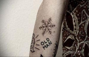 Фото тату снежинки и надписи "Old Man". Черно-белый рисунок татуировки, выполненный в минималистичном стиле, выглядит необычно и стильно.
