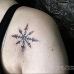 Фото тату с изображением маленькой снежинки, выполненной тонкими линиями. Черно-белый рисунок татуировки выглядит нежно и изящно, идеально подходит для женского тела.