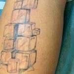 Фото необычной татуировки с изображением кубиков льда и надписью "Cooling". Стильный рисунок татуировки на руке.