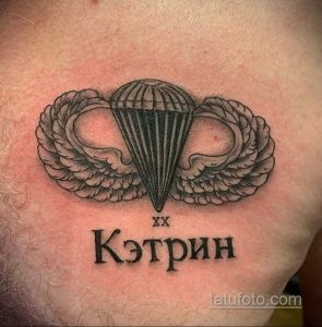 Фото тату на груди с изображением парашютного берета и надписью 'Кэтрин'. Черно-белый рисунок татуировки выполнен в реалистичном стиле.