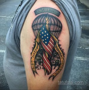 Фото татуировки с изображением парашюта, американского флага и надписи '82nd AIRBORNE' на плече. Цветная татуировка в традиционном стиле.